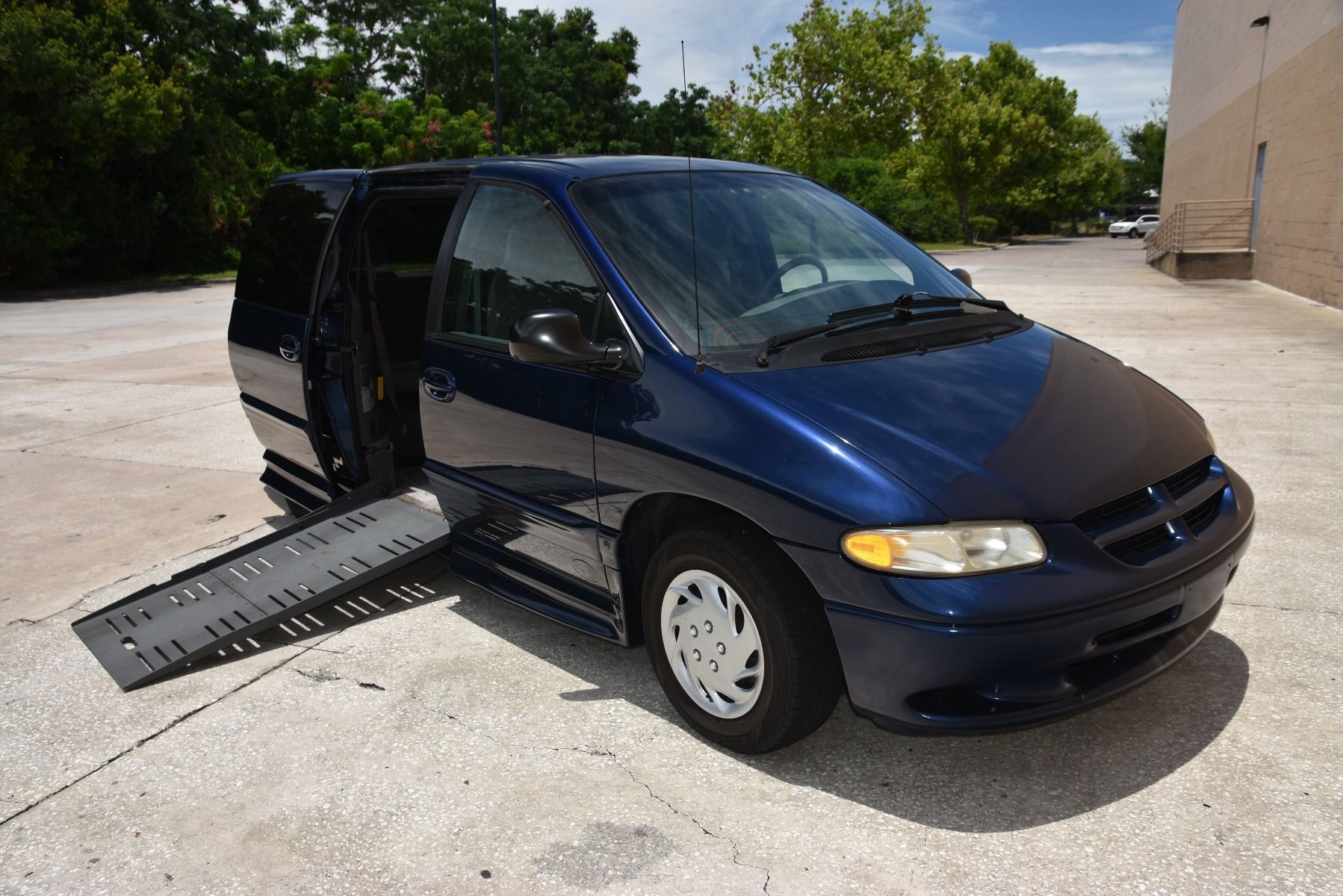 Passenger Side of a Blue Dodge Grand Caravan Wheelchair Van with ramp deployed, as seen from front angle