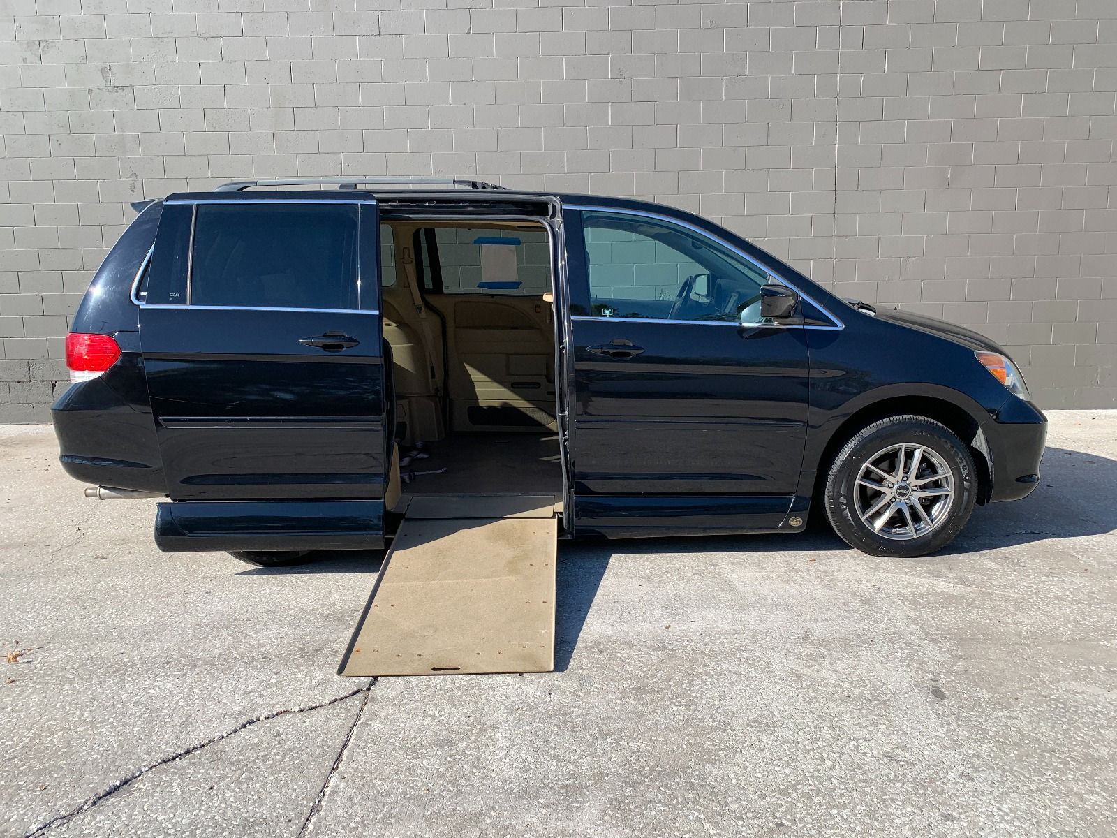 Passenger Side of a Black 2008 Honda Odyssey Wheelchair Van with ramp deployed