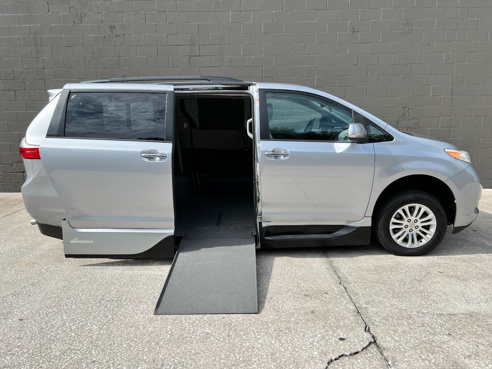 Silver Toyota Sienna wheelchair van with ramp deployed
