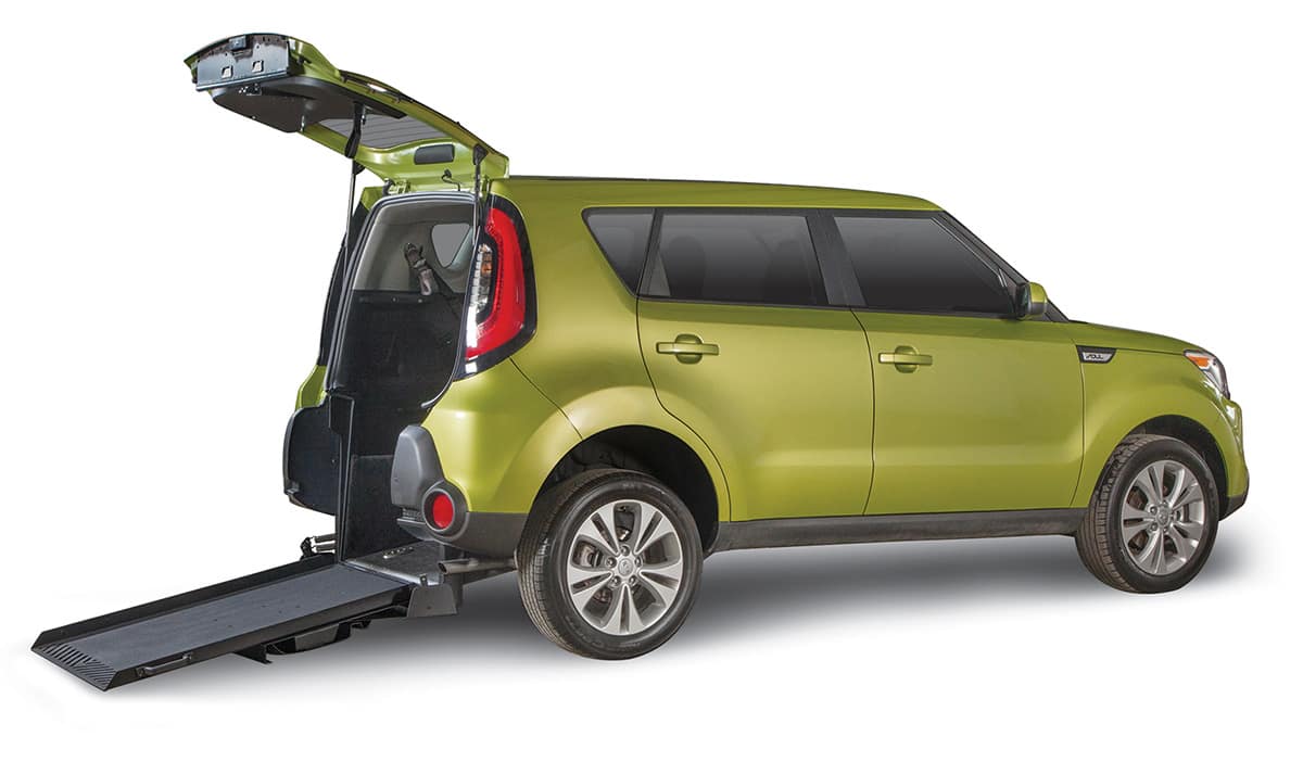 Green Wheelchair Accessible Kia Soul SUV with ramp deployed from open rear hatch.